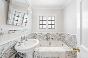 a white bathroom with a sink and a tub at Luxurious Seaside Escape-150 Steps to the Beach-Panoramic Ocean Views in Laguna Beach +48 photos