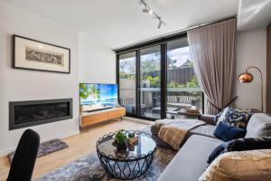 メルボルンにあるChic Townhouse in South Yarraのソファと暖炉のあるリビングルーム