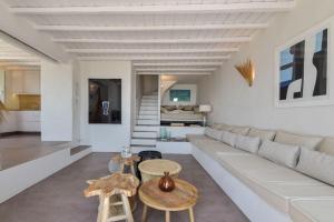 a living room with a white couch and tables at Lobster House Tinos in Arnados