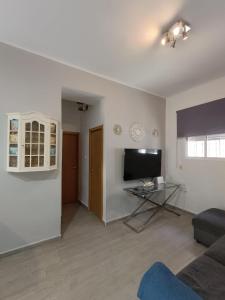 a living room with a couch and a tv at Apartamento La Domus in Cádiz