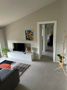 a living room with a couch and a flat screen tv at Modern loft FREE PARKING, Old watermill in Montorio Veronese