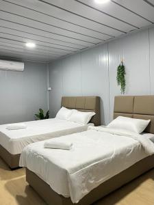 two beds sitting next to each other in a bedroom at Tiny House Merchang, Marang Roomstay Homestay in Kampong Pulau Rusa Baru +35 photos
