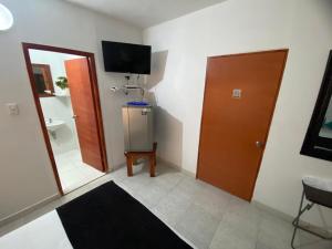 Cette chambre comprend un miroir, une porte et une télévision. dans l'établissement Paraíso en Bocagrande habitaciones, à Carthagène des Indes