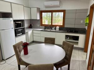 a kitchen with a white table and a white refrigerator at Casa Amarela com Vista para o Mar in Arroio do Sal