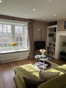 a living room with a couch and a window at Charlton Old Farm Guesthouse in Greenhaugh