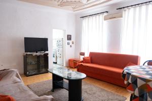 a living room with a red couch and a tv at Gera's house in Bitola