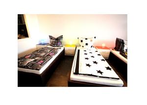 a bedroom with two beds with black and white pillows at Appartments über den Wolken in Fürth