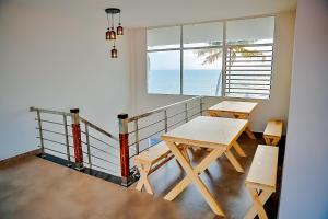 a table and chairs in a room with a view of the ocean at Waves 'n' Winds Alleppey in Alleppey