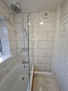 ein Badezimmer mit Dusche und Badewanne in der Unterkunft SleepyStays 3 Bedroom Modern & Central Location in Merthyr Tydfil