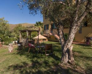een tafel en stoelen onder een boom naast een gebouw bij Villa Tresino Appartamenti in Castellabate