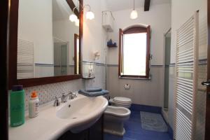 łazienka z umywalką, toaletą i lustrem w obiekcie Villa Tresino B&B w mieście Santa Maria di Castellabate