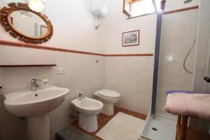 łazienka z umywalką, toaletą i lustrem w obiekcie Villa Tresino B&B w mieście Santa Maria di Castellabate