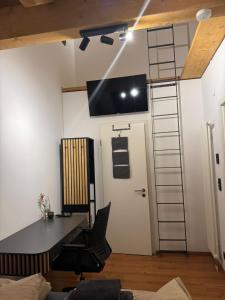 an office with a desk and a tv on the wall at Modernes und helles Apartment VS in Villingen-Schwenningen