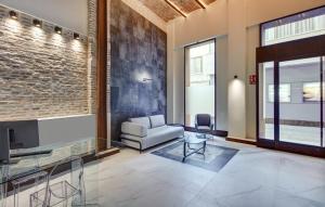 a living room with a couch and a tv at Sercotel Granada Suites in Granada