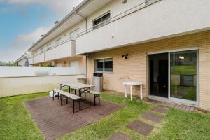 un patio con mesa y bancos frente a un edificio en Paradise Villa, en Esposende