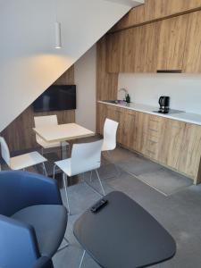 a room with a table and chairs and a kitchen at Aparthotel Apartamenty Czarna Góra 409 in Sienna