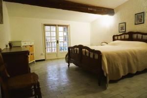 a bedroom with a bed and a table and a window at La maison du vigneron 7 personnes, proche plage avec clim in Fitou