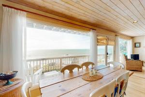 a dining room with a table and a view of the ocean at Oceanfront Delight in Cayucos