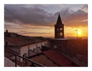 a sunset over a city with a clock tower at Dimora Vicolo Leoncini in Tivoli