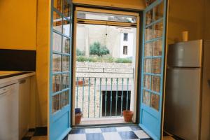 a kitchen with a door open to a balcony at La maison du vigneron 7 personnes, proche plage avec clim in Fitou +43 photos