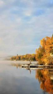 Saint-Bruno-de-MontarvilleにあるPeaceful Queen Room Free Parkingの湖の桟橋に座る者