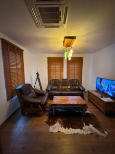 a living room with a leather couch and a coffee table at Rustik Home in Kotel