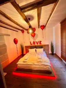 a bedroom with a bed with a love sign on the wall at Rustik Home in Kotel +23 photos
