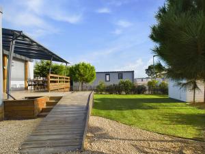 a wooden deck in a yard with a house at Beau Chalet pour 4 pers - Accès piscine chauffée in Brétignolles-sur-Mer