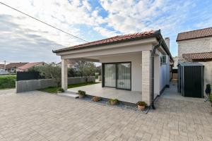 a small house with a patio in a yard at Holiday home San Antonio in Bibinje