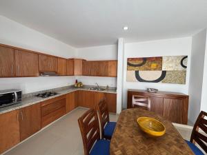 a kitchen with wooden cabinets and a table with chairs at 2br 1ba Condo 1 block to ocean Condo 1 in Mazatlán