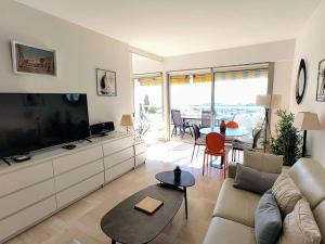 a living room with a large flat screen tv at Appartement Moderne 4 Pers avec Clim et Parking, Villeneuve-Loubet Plage - FR-1-252A-36 in Villeneuve-Loubet