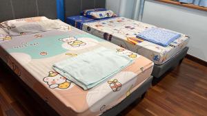 two twin beds in a room with hello kitty beds at Hock Lee Hotel Residences - Anna 温馨公寓式的住宅 in Kuching