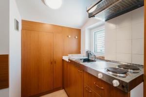 a kitchen with wooden cabinets and a sink at Villa Vujeva in Pag +100 photos