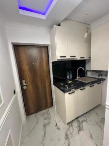 a kitchen with white cabinets and a wooden door at studio lipscani Old Town Center in Bucharest