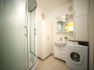 a bathroom with a washing machine and a sink at PaulMarie Apartments on Volotovskaya in Gomel