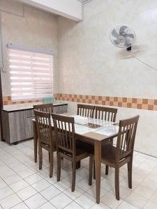a dining room with a table and chairs in a kitchen at INNAS Homestay in Seksyen 7, Shah Alam in Shah Alam
