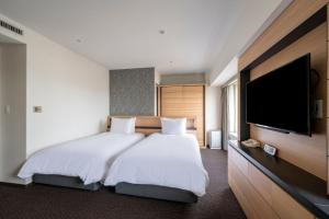 a bedroom with a large bed and a flat screen tv at ANA Crowne Plaza Sapporo by IHG in Sapporo