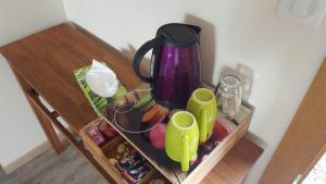 a table with a tea pot and cups on it at La Berceenne in Jupilles