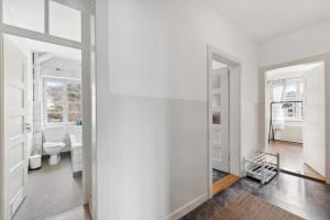 ein Badezimmer mit weißen Wänden und einem Spiegel in der Unterkunft Basic Apartment with Full Kitchen in Zürich