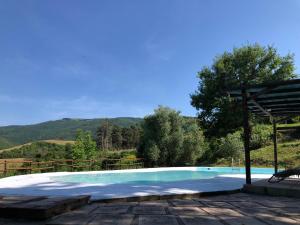 a swimming pool with a gazebo and mountains in the background at CASA VACANZE per Famiglie Agriturismo Montepolo in Canavaccio di Urbino