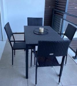 a black table and chairs on a balcony at Appartement tout confort climatisé in Gruissan +3 photos