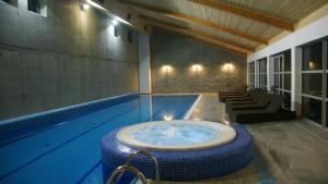 a swimming pool with a tub in the middle of it at Montebello Bussines & SPA in Ustroń