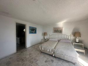 1 dormitorio con 1 cama, 2 lámparas y puerta en Casa Mayherz, en Acapulco