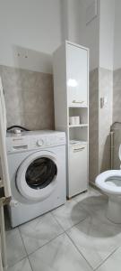 a washing machine in a bathroom with a toilet at M Family Apartment in Odorheiu Secuiesc