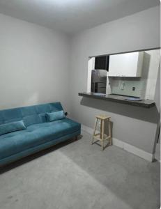 a living room with a blue couch and a stool at Sol e Mar 500 metros da praia in Vitória