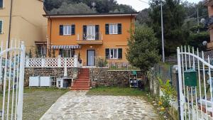 una casa naranja con una escalera delante de ella en Tipica villetta ligure indipendente arredata con gusto e comfort 1 camera da letto parcheggio interno zona Lerici Monti San Lorenzo, en Lerici