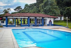 a swimming pool in front of a house at Siete Sentidos Estancia de Aves in La Mesa