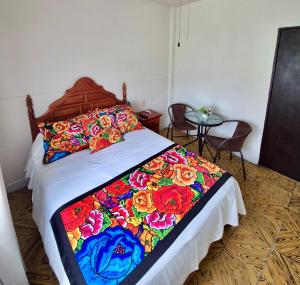a bedroom with a bed with a colorful blanket on it at Hotel Catalina in Orizaba +10 photos
