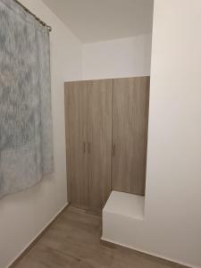 a room with a wooden cabinet and a curtain at Haraki Blue Houses in Haraki