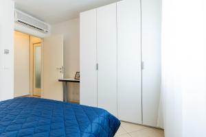 a bedroom with white cabinets and a blue bed at Villaggio Sant' Andrea in Caorle +68 photos